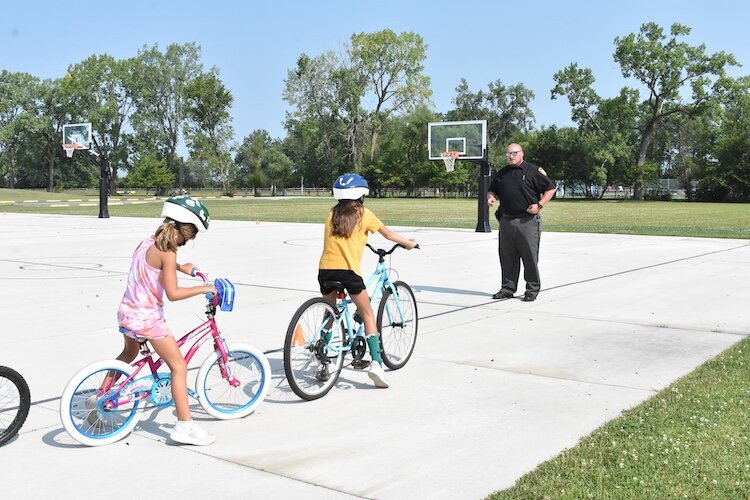 An Ottawa County Sheriff Deputy leads a learning session at the Bike Safety Camp for area children conducted by the Friends of Ottawa County Parks.