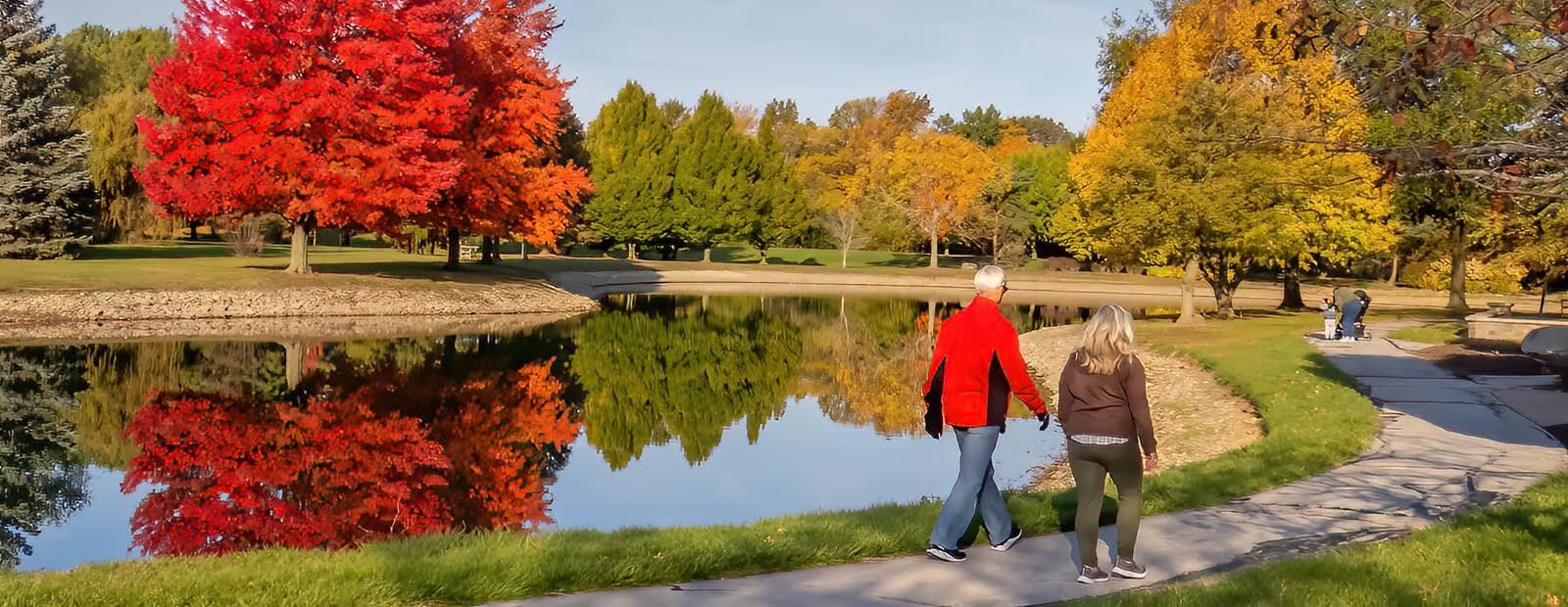 Visitors at the James H. McBride Arboretum enjoy the fall color as they walk around the pond.