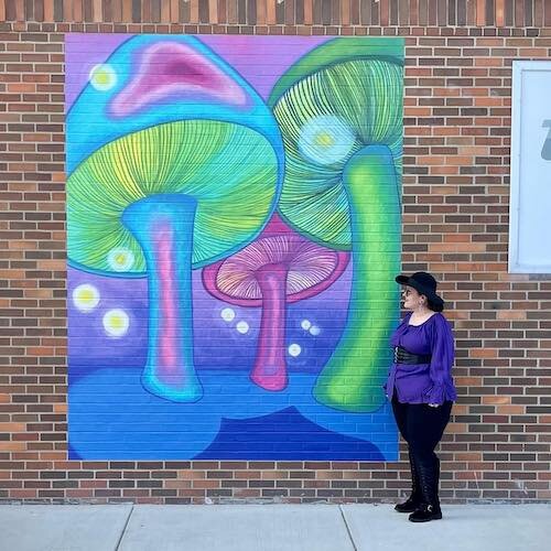 Jen Robinson stands with her mural, "Shrooms," in downtown Sandusky.