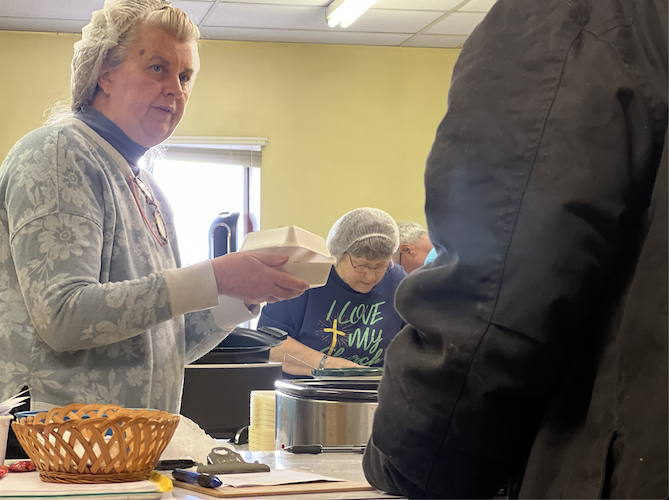 Carolyn Springer serves a guest at the Nov. 23 breakfast service.