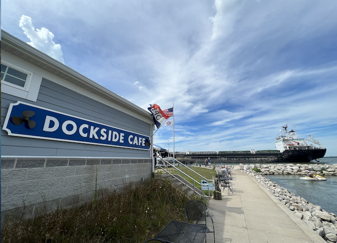 A freighter in Sandusky Bay passes Dockside Cafe.