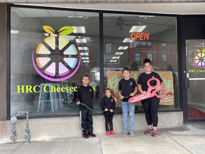 Hartley poses with her children outside of HRC Cheesecakes on its opening day.