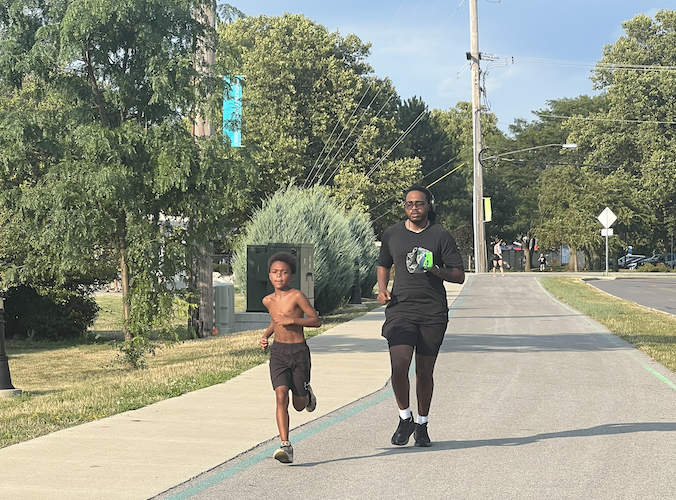 Shykel Jones runs with his son Keldon during the first group run on July 30.