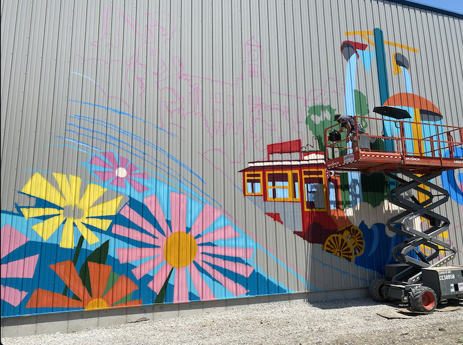 Brennan fills in trees next to his rendering of the Red Popcorn Wagon.