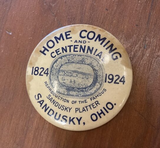 Even more rare is the centennial button on display with the Sandusky platter. 