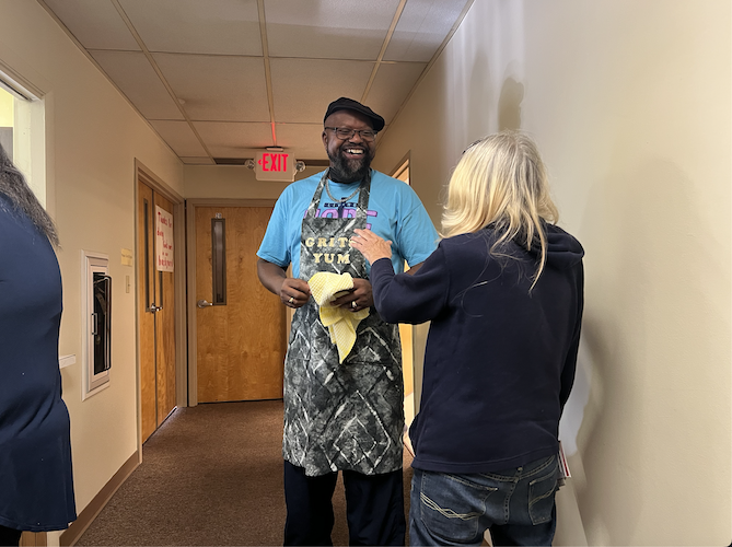 A community member praises Doward for his morning batch of grits.